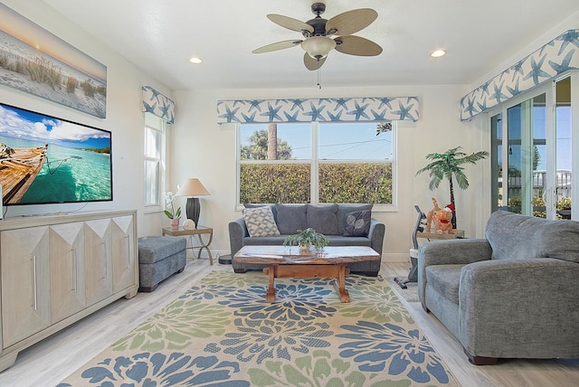 living area with recessed lighting, ceiling fan, light wood-style flooring, and baseboards