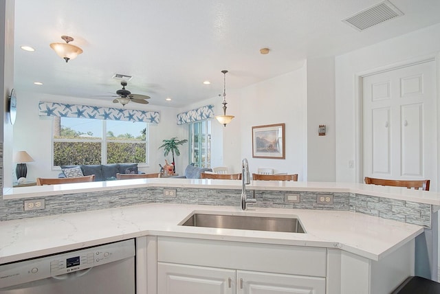 kitchen featuring visible vents, a sink, stainless steel dishwasher, and white cabinetry