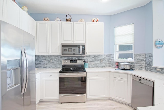 kitchen with white cabinets, stainless steel appliances, and decorative backsplash