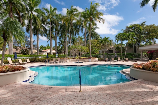 community pool featuring fence and a patio