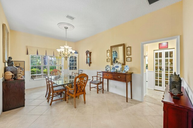 dining space featuring a chandelier, wainscoting, visible vents, and light tile patterned flooring