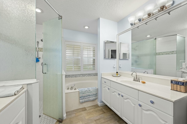 bathroom featuring a stall shower, a textured ceiling, and a bath