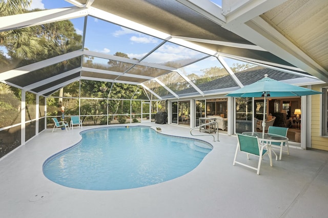 outdoor pool featuring a patio and glass enclosure