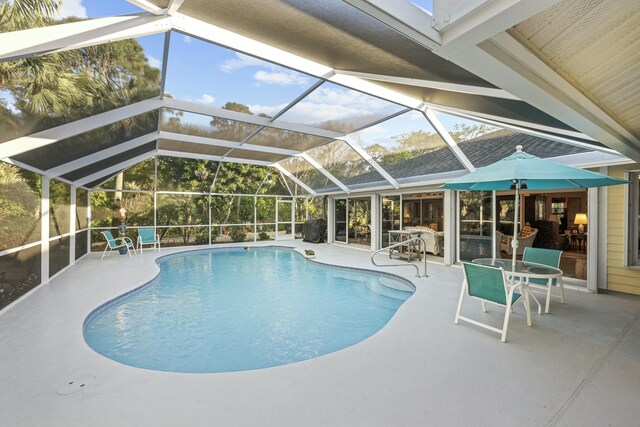 pool featuring glass enclosure, a patio area, and grilling area