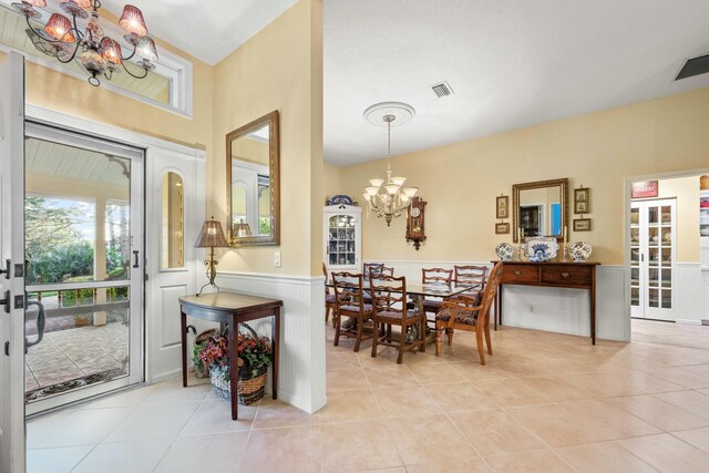 living area with a wainscoted wall, ceiling fan, vaulted ceiling, and light wood finished floors