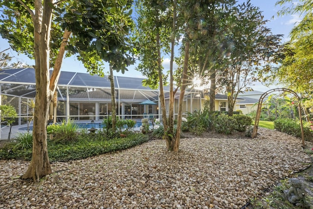 back of property featuring a lanai and an outdoor pool