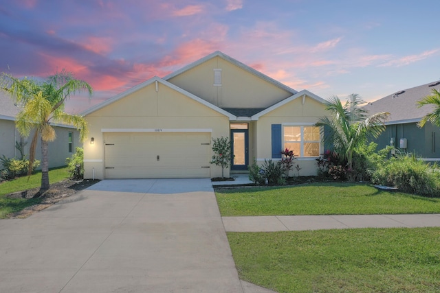 single story home featuring a garage, driveway, a front lawn, and stucco siding