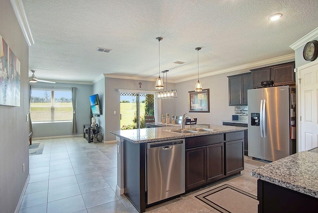 kitchen featuring visible vents, an island with sink, ornamental molding, stainless steel appliances, and a sink