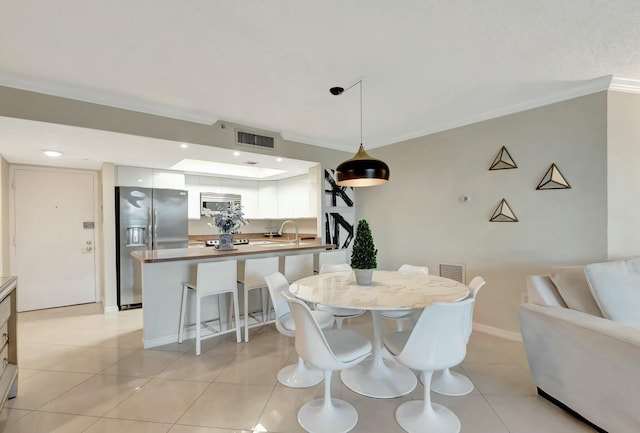 dining space featuring light tile patterned floors, ornamental molding, visible vents, and baseboards