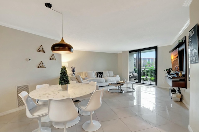 dining area with visible vents, crown molding, baseboards, and light tile patterned floors