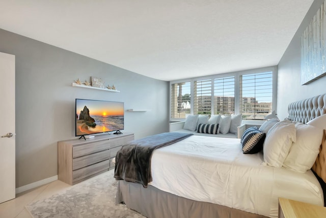 bedroom with light tile patterned flooring and baseboards