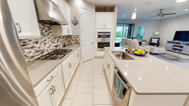 9592 SW Royal Poinciana Dr, Port Saint Lucie, FL 34987 - kitchen with open floor plan, stainless steel appliances, a sink, and under cabinet range hood