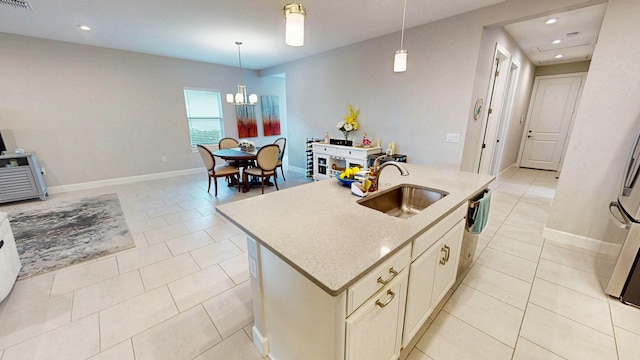 9592 SW Royal Poinciana Dr, Port Saint Lucie, FL 34987 - kitchen featuring light tile patterned floors, baseboards, an island with sink, decorative light fixtures, and a sink