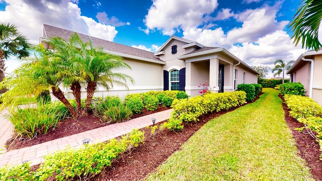 view of front of property featuring a front lawn and stucco siding