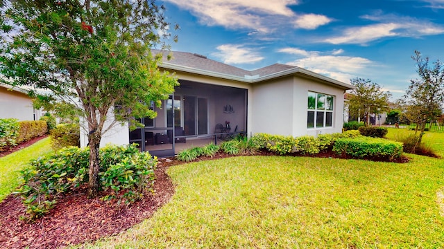 9592 SW Royal Poinciana Dr, Port Saint Lucie, FL 34987 - rear view of property with a yard, a shingled roof, a sunroom, and stucco siding