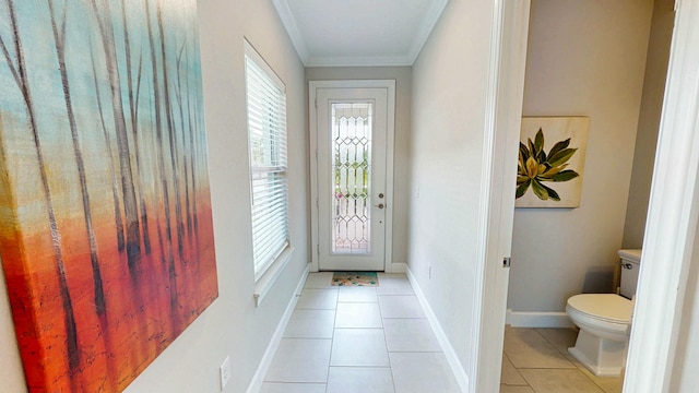 doorway to outside with ornamental molding, light tile patterned flooring, and baseboards