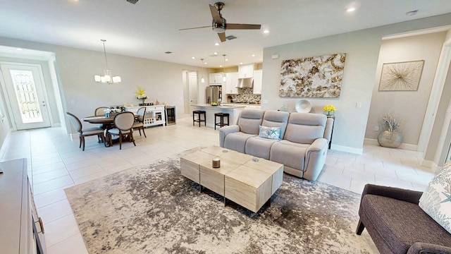 9592 SW Royal Poinciana Dr, Port Saint Lucie, FL 34987 - living area with light tile patterned floors, recessed lighting, ceiling fan with notable chandelier, visible vents, and baseboards