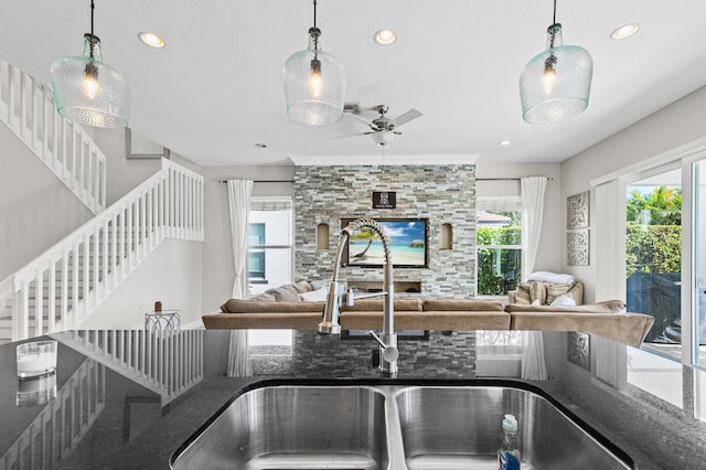 kitchen with a fireplace, pendant lighting, a sink, and recessed lighting