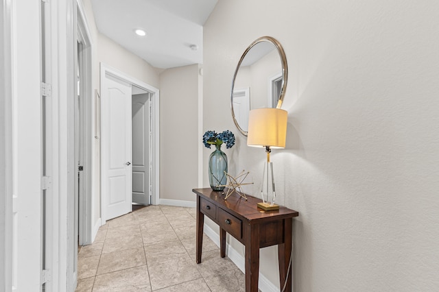 hallway featuring baseboards and light tile patterned flooring