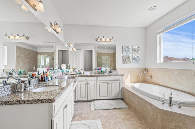 bathroom featuring plenty of natural light, a stall shower, a garden tub, and a sink