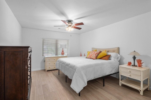 bedroom with a ceiling fan, light wood-style flooring, and baseboards