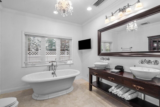 bathroom with visible vents, a freestanding bath, an inviting chandelier, ornamental molding, and a sink