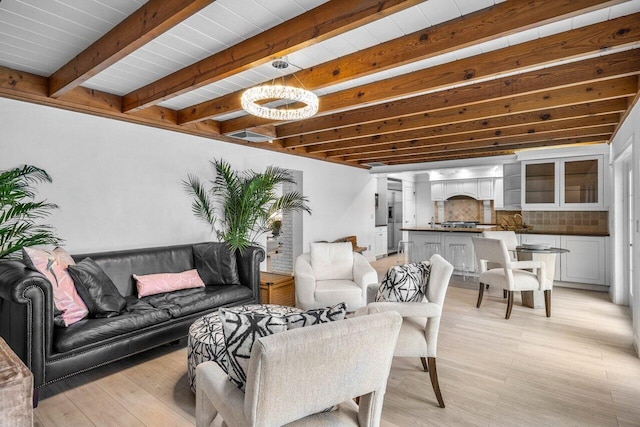 living room featuring light wood finished floors and beam ceiling