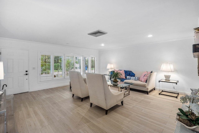 living area featuring visible vents, baseboards, light wood-style flooring, ornamental molding, and recessed lighting