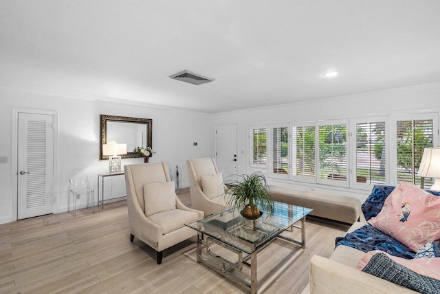 living area with light wood-type flooring, a healthy amount of sunlight, and visible vents