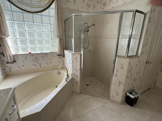 full bathroom featuring tile patterned flooring, a garden tub, a shower stall, and wallpapered walls