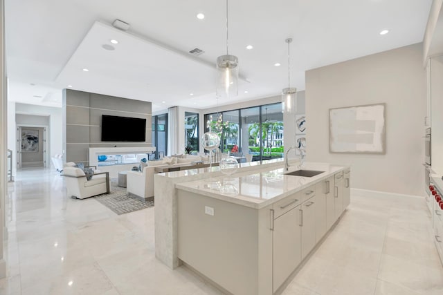 kitchen featuring recessed lighting, a sink, white cabinetry, an island with sink, and modern cabinets