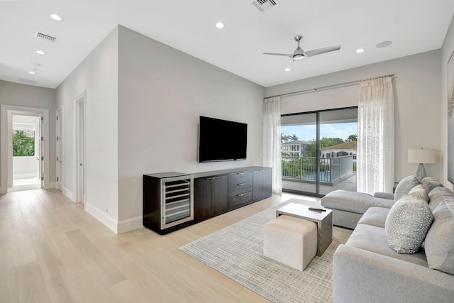 living area with beverage cooler, visible vents, light wood-style flooring, and recessed lighting