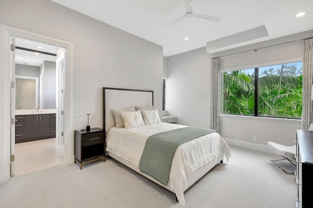 bedroom featuring ensuite bathroom, recessed lighting, light colored carpet, a sink, and baseboards