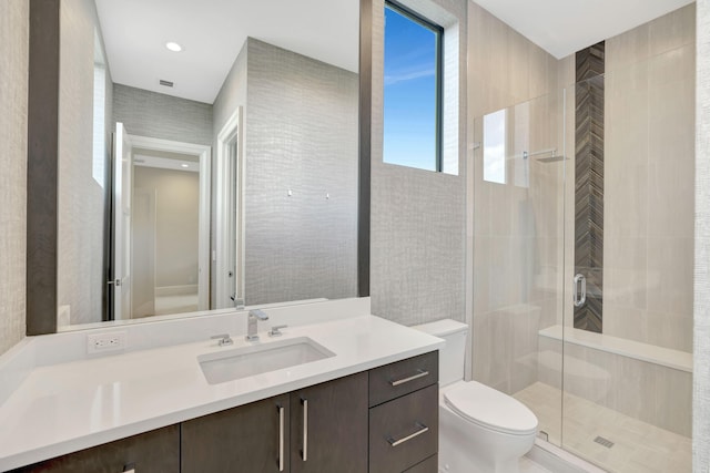 bathroom featuring toilet, a shower stall, recessed lighting, and vanity