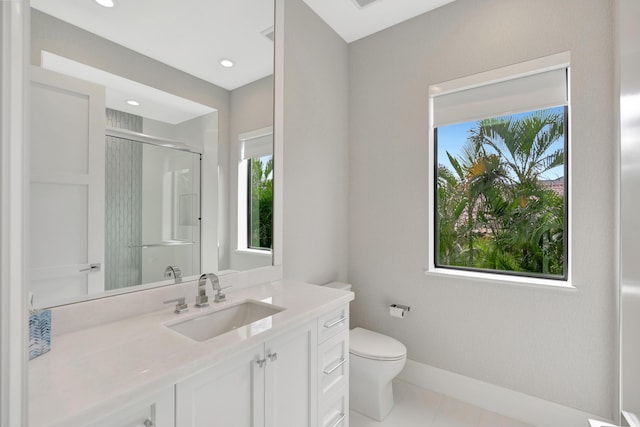 bathroom with toilet, a shower stall, vanity, baseboards, and tile patterned floors