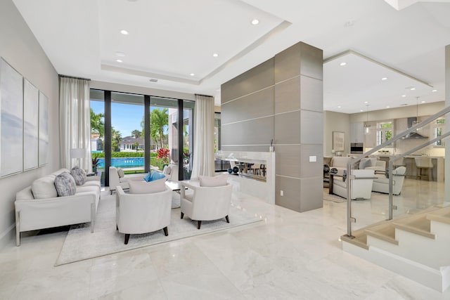 living area featuring plenty of natural light, a tray ceiling, and recessed lighting