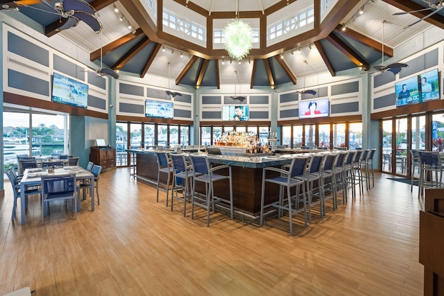 bar with ceiling fan, wood finished floors, and a wealth of natural light