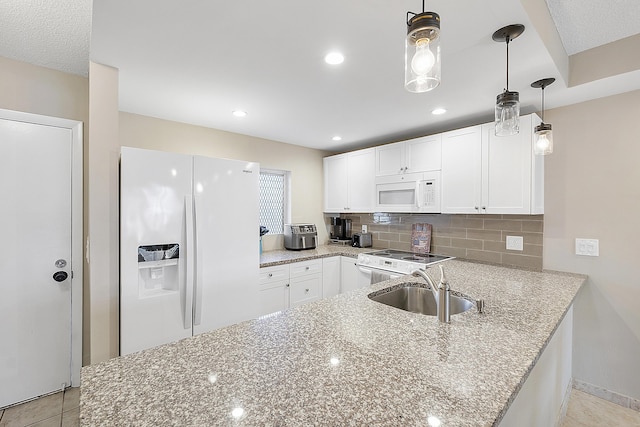 kitchen with light stone counters, white appliances, a sink, white cabinets, and backsplash