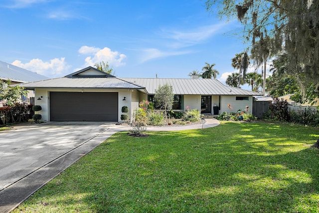 single story home featuring metal roof, an attached garage, fence, driveway, and a front lawn