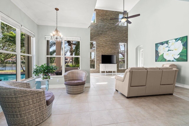 living room with a wealth of natural light, arched walkways, ornamental molding, and tile patterned floors