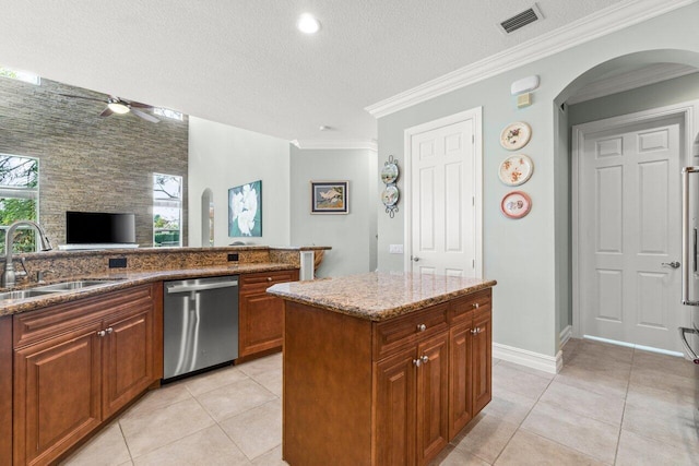 kitchen featuring light stone counters, arched walkways, visible vents, stainless steel dishwasher, and a sink