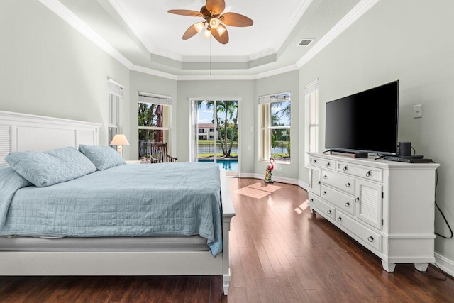 bedroom featuring access to exterior, a tray ceiling, dark wood-style flooring, visible vents, and ornamental molding