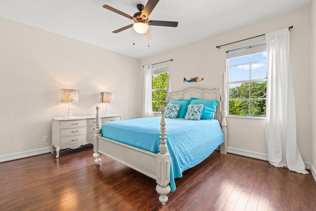 bedroom with dark wood-style flooring, ceiling fan, and baseboards