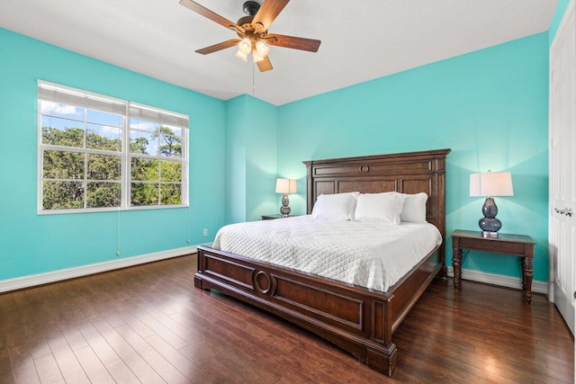 bedroom with dark wood-type flooring, ceiling fan, and baseboards