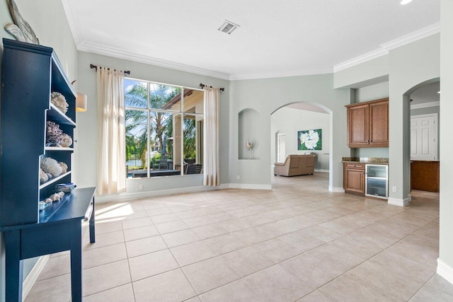 living area featuring wine cooler, visible vents, crown molding, and light tile patterned flooring