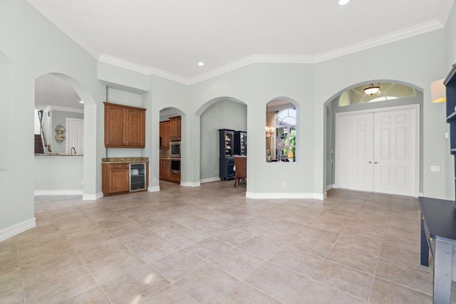 unfurnished living room with recessed lighting, ornamental molding, light tile patterned flooring, beverage cooler, and baseboards