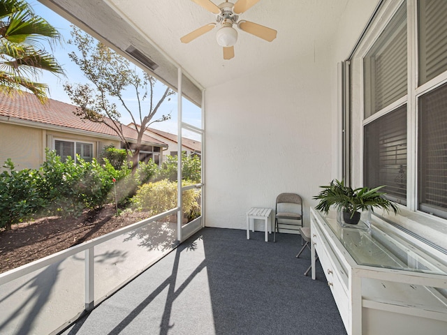 unfurnished sunroom featuring a ceiling fan