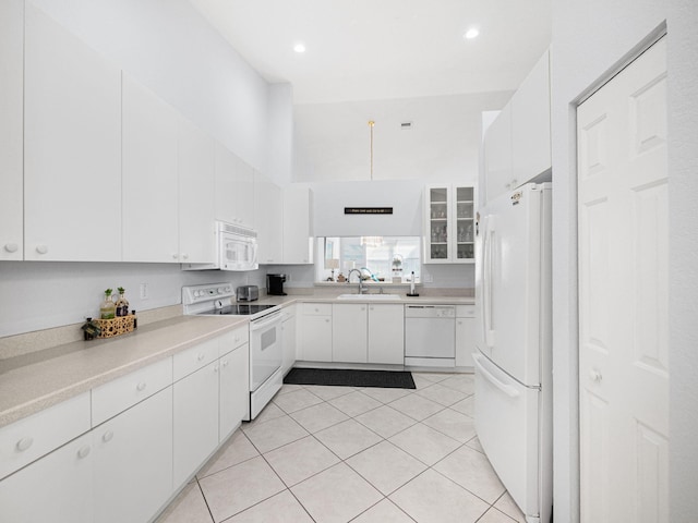 kitchen featuring white appliances, white cabinetry, and light tile patterned flooring