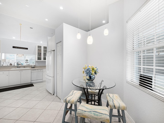 kitchen with white appliances, a sink, white cabinetry, light countertops, and glass insert cabinets