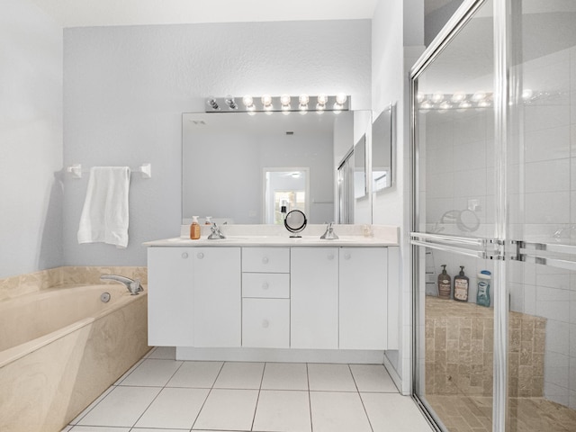 full bathroom with double vanity, a garden tub, a shower stall, and tile patterned flooring